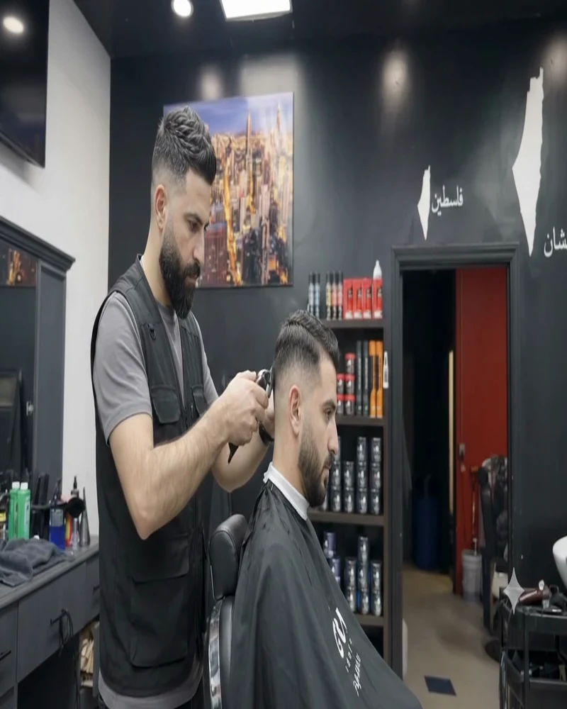 Barber cutting a client's hair in the shop chair